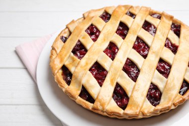 Delicious fresh cherry pie on white wooden table, closeup