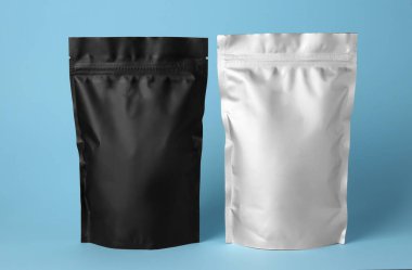 Different blank foil packages on light blue background