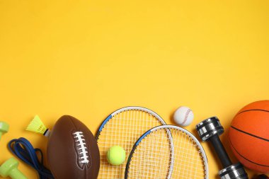 Set of different sports equipment on yellow background, flat lay. Space for text