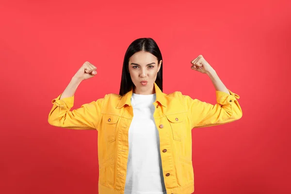 Strong woman as symbol of girl power on red background. 8 March concept