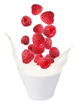 Delicious ripe raspberries falling into bowl with yogurt on white background