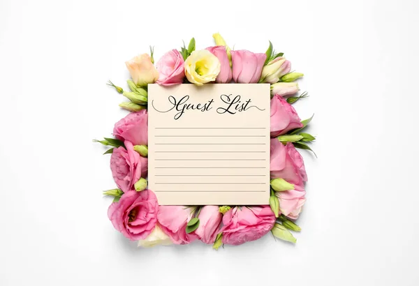Guest list and beautiful flowers on white background, top view