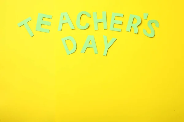 Words TEACHER\'S DAY on yellow background, flat lay. Space for text