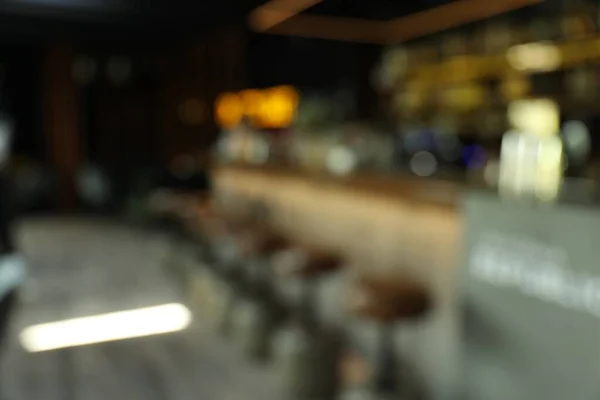 Blurred view of stylish modern bar interior with bokeh effect