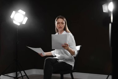 Tiyatroda prova sırasında senaryosunu okuyan profesyonel bir aktris.