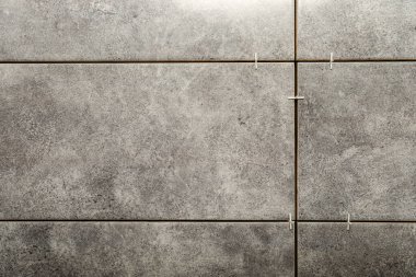 Stylish tiles with spacers on wall in room