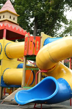 Children's playground with bright slide on summer day