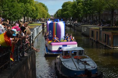 AMSTERDAM, NETHERLANDS - AUGUST 06, 2022: Many people in boats at LGBT pride parade on river