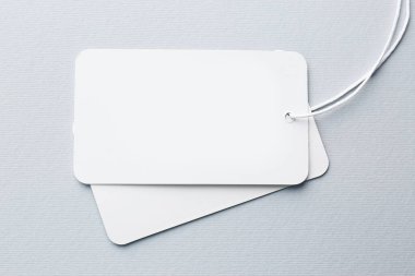Tags with space for text on light grey background, top view