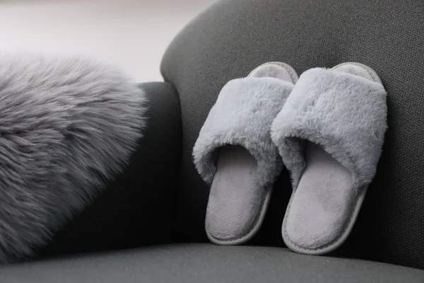 Soft grey slippers and faux fur on sofa