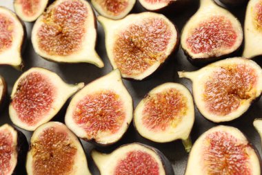 Delicious cut raw figs on light grey table, closeup