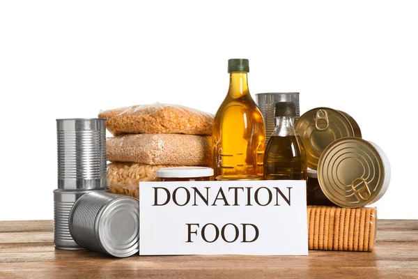 Card with words Donation Food and different products on wooden table against white background