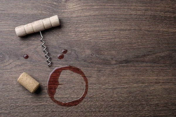 Wine stain, corkscrew and stopper on wooden table, flat lay. Space for text