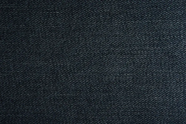 Texture of dark blue jeans as background, closeup
