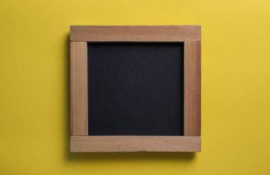 Blank chalkboard on yellow background, top view. Space for text