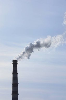 Mavi gökyüzüne karşı endüstriyel bacadan çıkan dumanla havayı kirletiyor. CO2 emisyonları