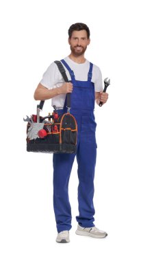 Professional plumber with tool bag and adjustable wrench on white background