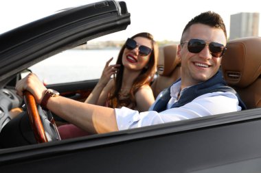 Lüks, üstü açık araba kullanan şık bir çift.