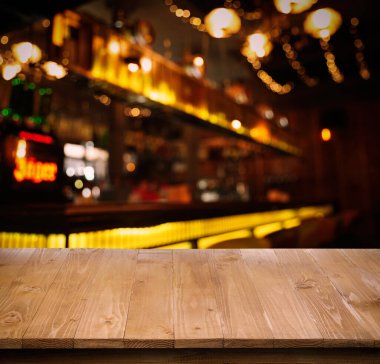 Empty wooden surface and blurred view of bar interior. Space for design
