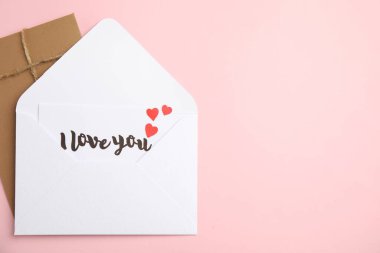 Love letter and envelope on pink background, flat lay. Space for text