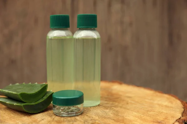 Bottles Cosmetic Products Sliced Aloe Vera Leaves Wooden Stump Space — Φωτογραφία Αρχείου