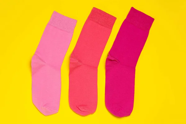 Different Pink Socks Yellow Background Flat Lay — стоковое фото
