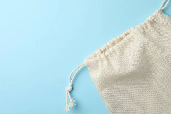 Cotton eco bag on light blue background, top view. Space for text