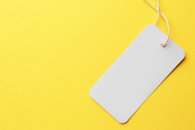 Tag with space for text on yellow background, top view