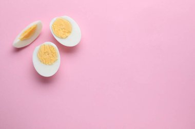 Fresh hard boiled eggs on pink background, flat lay. Space for text