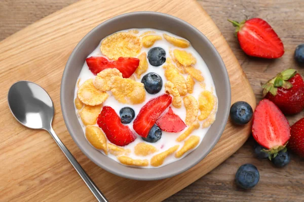 Bowl Tasty Crispy Corn Flakes Milk Berries Wooden Table Flat — Zdjęcie stockowe