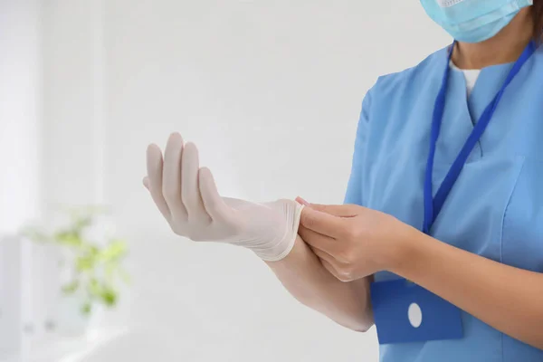 Dokter Zet Medische Handschoenen Tegen Wazig Achtergrond Close — Stockfoto