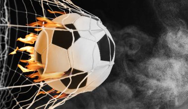 Soccer ball with fire in net against black background