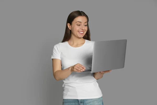 Młoda Kobieta Nowoczesnym Laptopem Szarym Tle — Zdjęcie stockowe