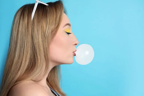 Fashionable Young Woman Bright Makeup Blowing Bubblegum Light Blue Background — Fotografia de Stock