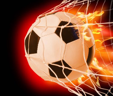 Soccer ball with fire in net on color background