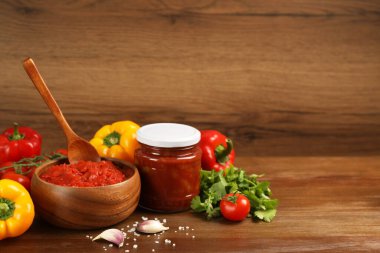 Delicious lecho and fresh ingredients on wooden table. Space for text