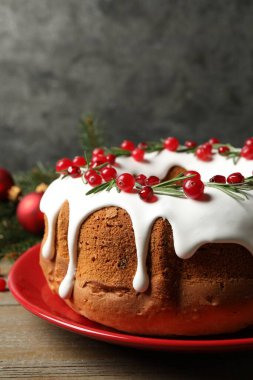 Geleneksel Noel pastası jöle, nar tohumu, kızılcık ve biberiye ile süslenmiş ahşap masa.