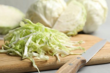 Gri masada taze doğranmış lahana, yakın plan.