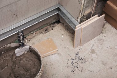 Adhesive mix and ceramic tiles on floor indoors