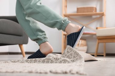 Man tripping over rug at home, closeup