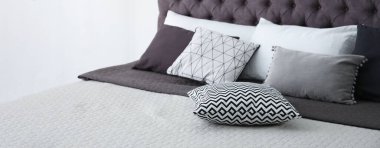 Soft pillows on stylish bed in room. Banner design