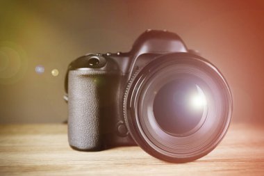 Digital camera of professional photographer on wooden table