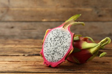Lezzetli kesim ve tüm ejderha meyveleri (pitahaya) ahşap masada.