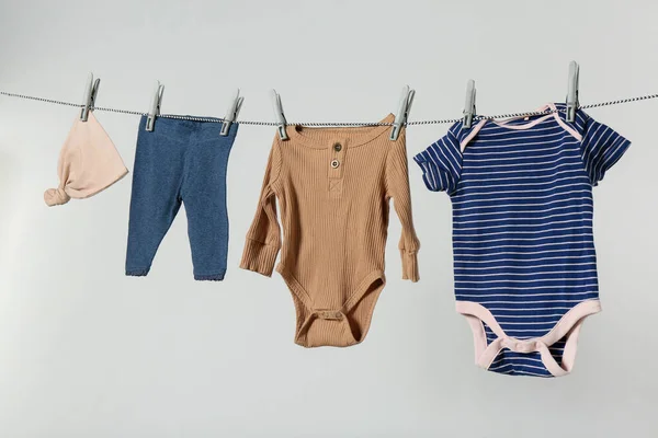 Different Baby Clothes Drying Laundry Line Light Background — ストック写真