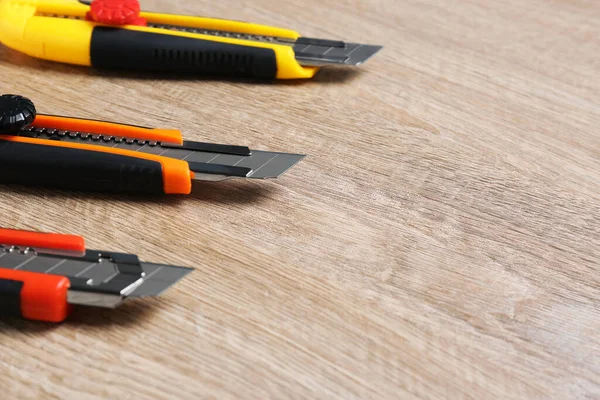 Three Utility Knives Wooden Table Closeup Space Text —  Fotos de Stock