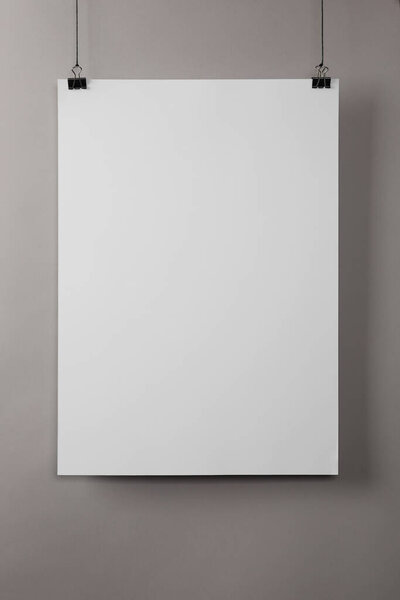 White blank poster hanging near grey wall