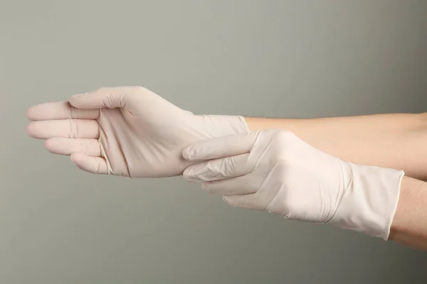 Person Putting Medical Gloves Grey Background Closeup Hands — стоковое фото