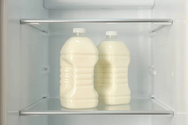 Gallons of fresh milk in refrigerator, closeup