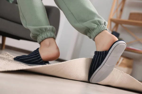 Man tripping over rug at home, closeup