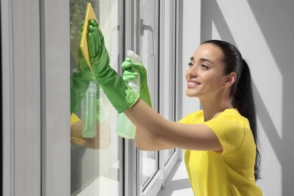 Jovem Feliz Limpeza Janela Vidro Com Pano Esponja Spray Dentro — Fotografia de Stock